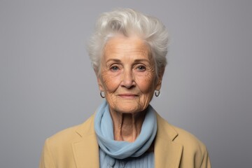 Portrait of a happy senior woman with grey hair over grey background