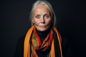 Portrait of a beautiful senior woman with scarf on a black background