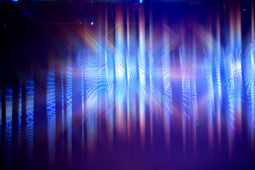 Blue theater curtain background with stage multicolored lighting.
