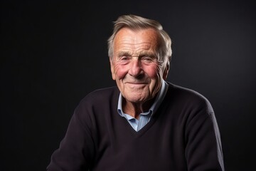Portrait of an elderly man on a dark background. Studio shot.