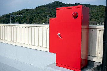 A fire hydrant box is placed on the rooftop of a building. 