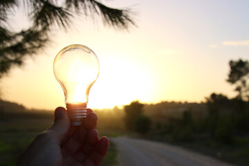 energy and business concept image. Creative idea and innovation. light bulb metaphor in front of the sun - obrazy, fototapety, plakaty