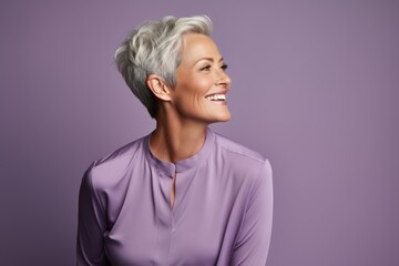 Beautiful smiling middle aged woman with short grey hair in purple shirt