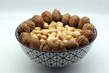Walnuts and peanuts  in a bow isolated on white backgroud