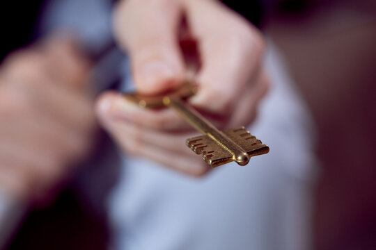  Close up of human hand holding golden key