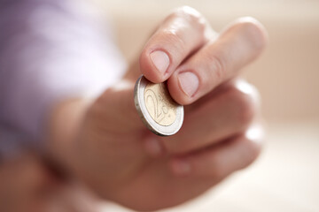 man handing euro coin in the hand