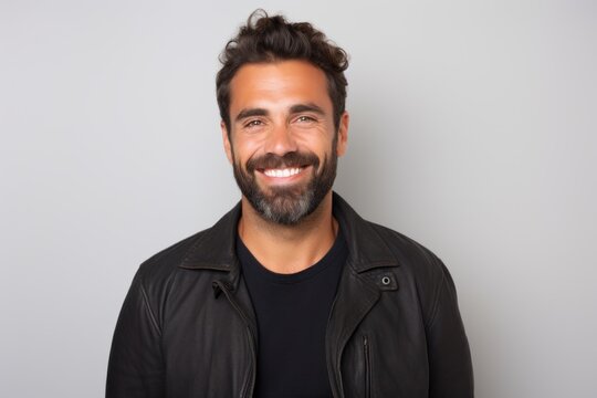 Portrait of a happy man smiling and looking at camera against grey background