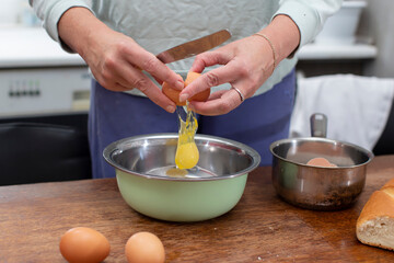 Obraz na płótnie Canvas Cook breakfast. Hands break eggs to prepare an omelet.