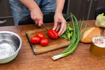 Chop the green onions and tomatoes and place them in a bowl. Prepare the salad.