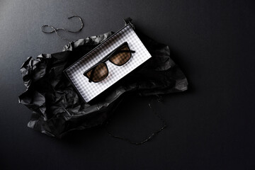 Black sunglasses in black wrapping paper