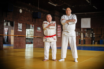 Two respected and experienced judo sensei master instructor in traditional gi kimono. A skilled...