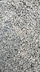 Rough texture of wall made of small gray cement pebbles. Small uneven gravel texture