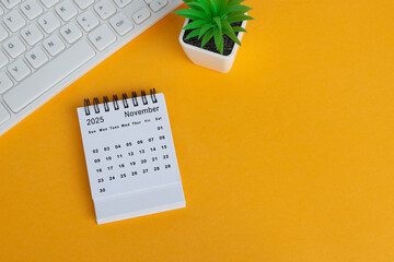 November 2025 desk calendar on yellow background. Directly above. Flat lay.