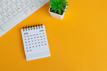 June 2025 desk calendar on yellow background. Directly above. Flat lay.