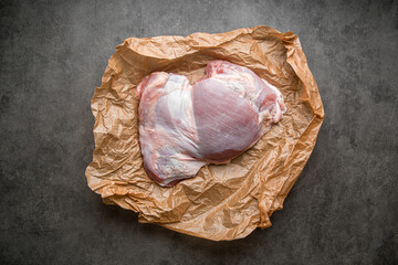 Raw boneless turkey thigh fillet on parchment paper