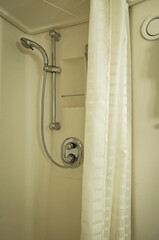 Modern design bathroom with sink, shower, towels and mirror and mosaic tiles in cabin or stateroom...