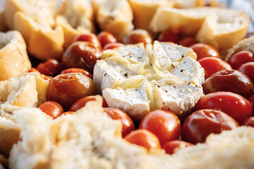 Camembert cheese baked with tomatoes and baguette.