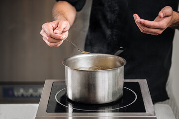 Fototapeta na wymiar Chef boiling water in a steel pot preparing food