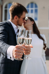 A man and woman kissing. They are both dressed formally and appear to be at a wedding or formal event. The woman