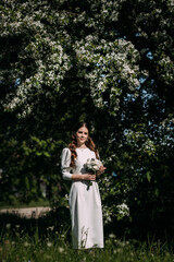 Fototapeta na wymiar A woman wearing a white dress standing outdoors near a tree 5190.