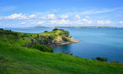 Obraz premium View of the Hauraki Gulf under a blue sky with white clouds. Waiheke Island. New Zealand.