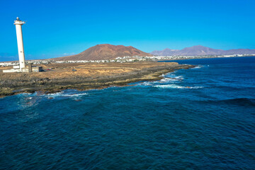 Playa Blanca coastline. Aerial drone panoramic view with Red volcano in the Background. Tourism and vacation concept. Flamingo beach  Lanzarote, Canary Islands, Spain.