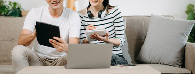  Female discussing new project with male colleague. Young woman talking with young Asian man with...