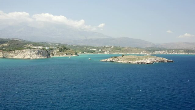 Drone footage of Karga island with Almyrida beach in the background in Crete island, Greece