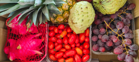Fresh exotic fruits like anona, pineapple, grapes, dragon fruits sold at the local market