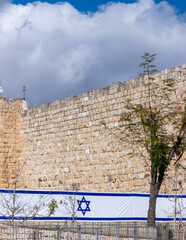 Large Israeli flag on Jerusalem's Old City Wall background - 704852287