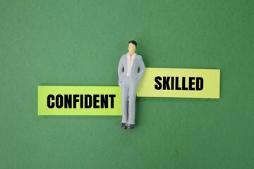 miniature people and colored paper with the words skilled and confident. the concept of self-skills