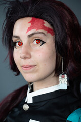 Caucasian female cosplayer in a blue costume with face paint and red contact lenses