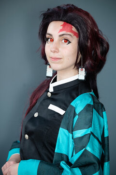 Caucasian female cosplayer in a blue costume with face paint and red contact lenses
