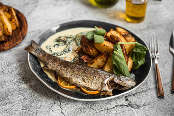 Portion of cooked grilled fish with potato and sauce