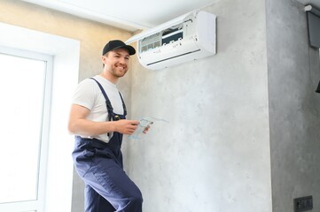 Service man is cleaning, repair and maintenance of air conditioner.