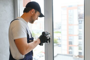 The foreman installs a window frame in the room