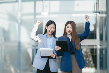 Asian business woman are excited business success with inspiration from their excellent financial results that are happy working.