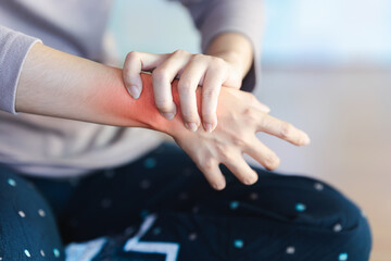 A woman's wrist is in pain and a red area is made to show the pain point.