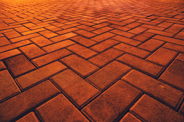 Texture of orange brick pavement in perspective as background.