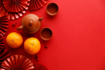 Chinese new year festival decorations with tangerines, classic clay teapot and red Chinese folded fans.