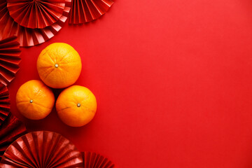 Chinese new year festival decorations with tangerines and red Chinese folded fans.