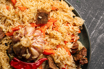 Large dish with Uzbek festive pilaf plov on grey background