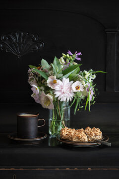 Mug of coffee, pieces of apple pie and blooming flowers in jar