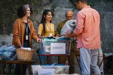 People sorting donated used clothes for charity
