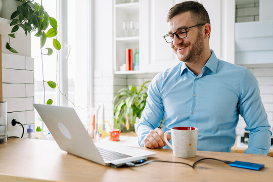Smiling freelancer doing video call on laptop at home