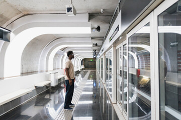 Man wearing futuristic glasses standing at metro station