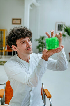 Businessman holding and examining cube shape maze in office