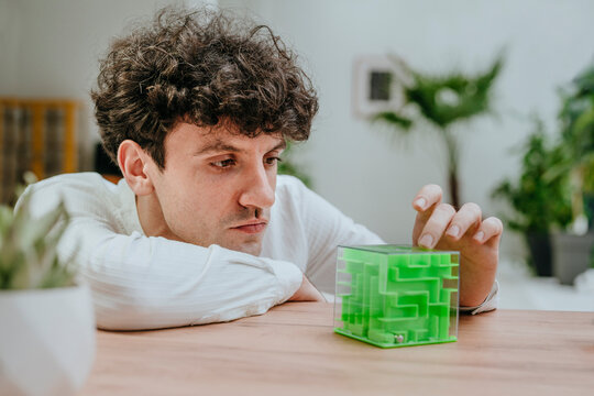 Businessman playing with cube maze at desk in office