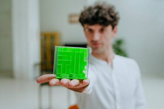 Businessman showing cube shape maze in office