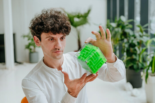 Businessman examining cube maze in office